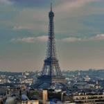 Eiffel tower from arc de triomphe in city against sky